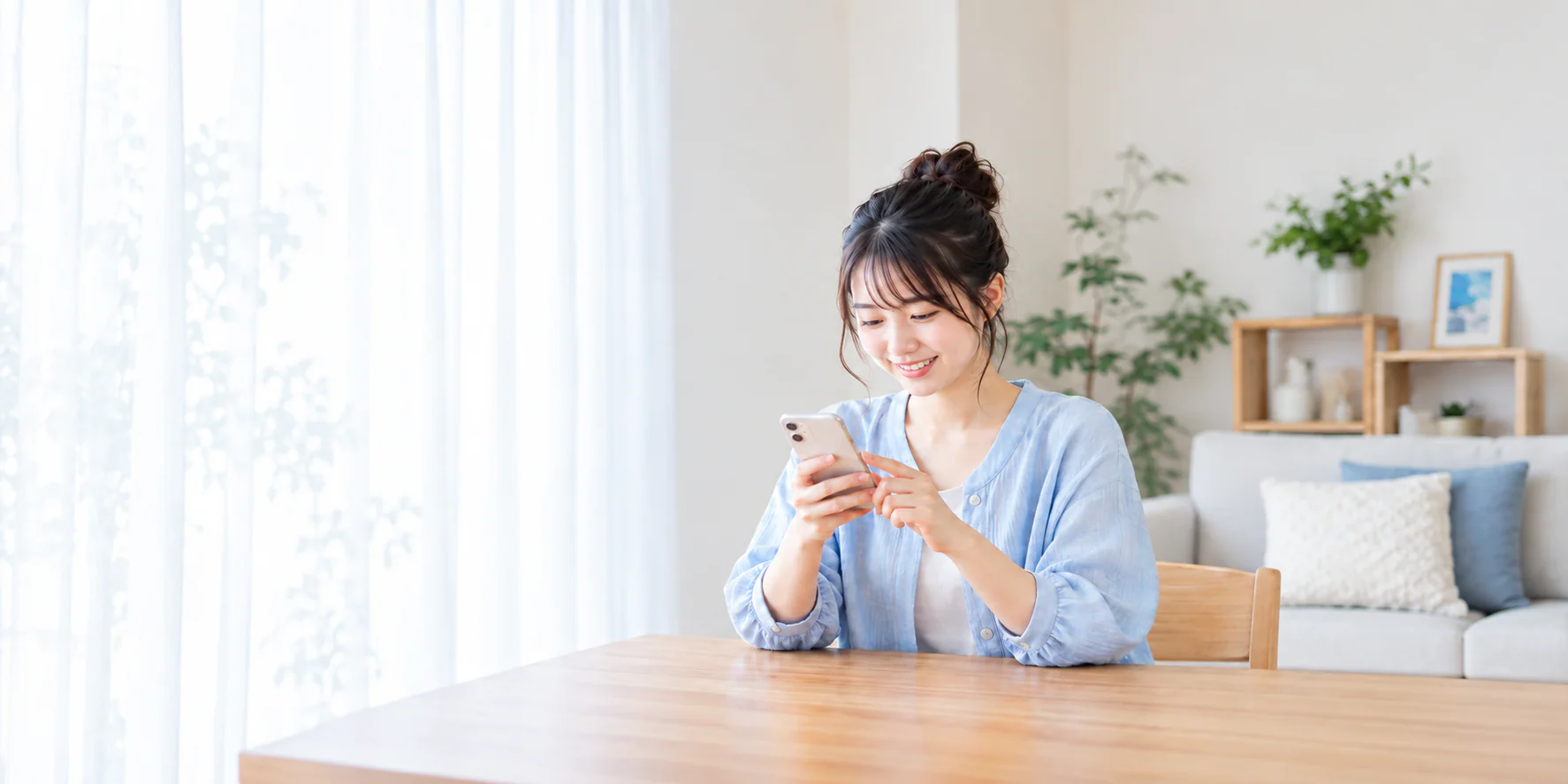自宅でスマートフォンを使い、お部屋について問い合わせる学生のイメージ