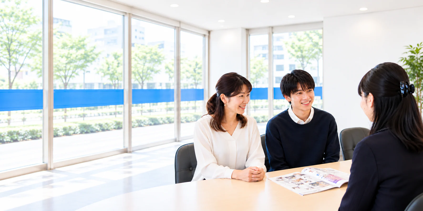明るい店舗で、学生とご家族がお部屋についてスタッフに相談する様子