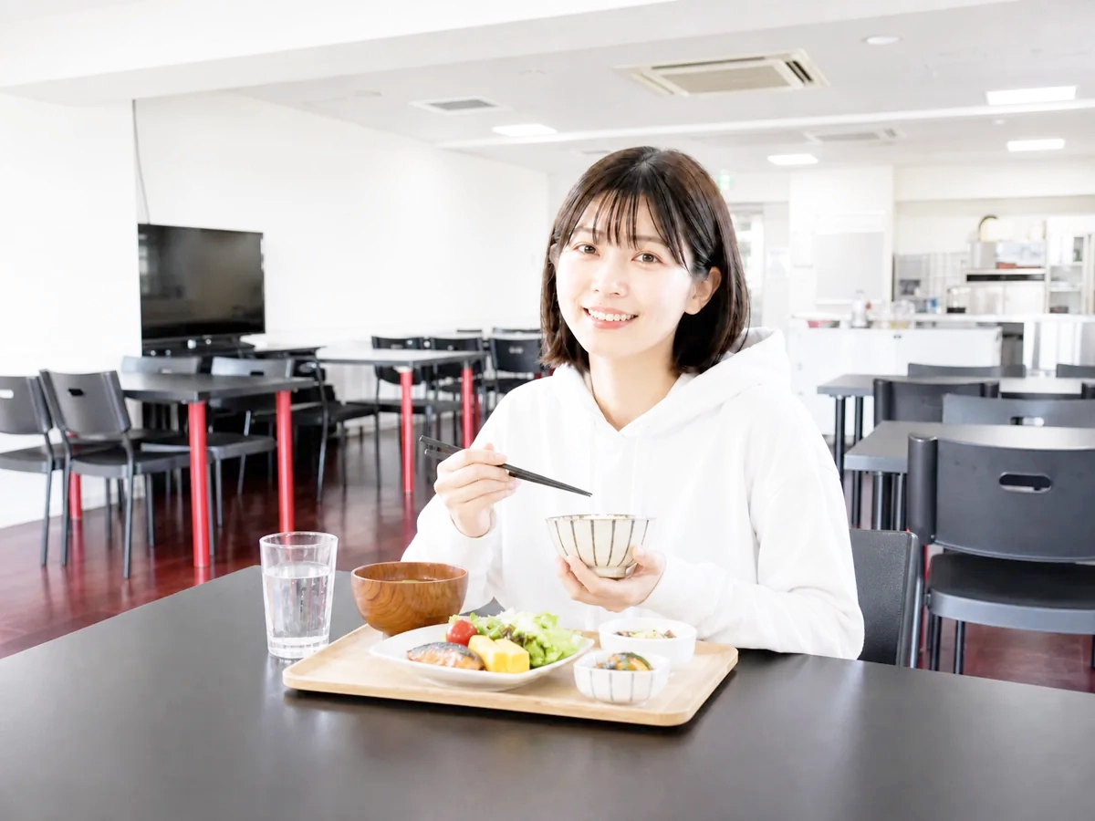 STキューブの食堂で朝食をとる女子大学生